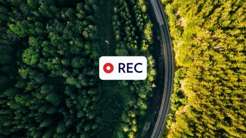 aerial view of road in wood with recording icon above it